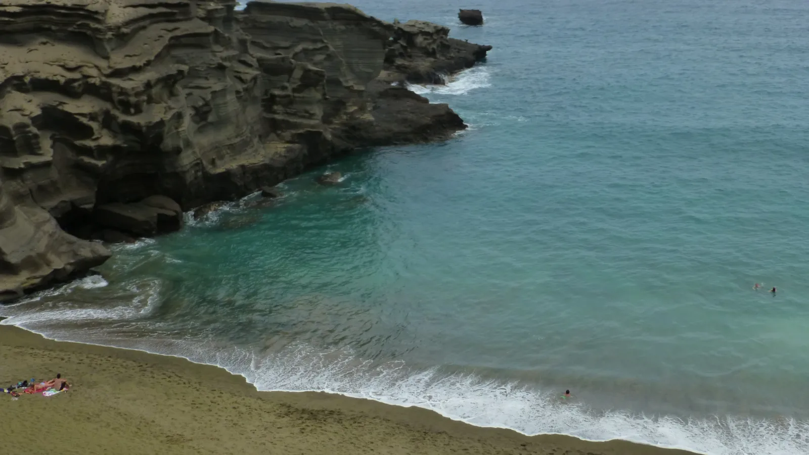 Papakolea Green Sand Beach auf Big Island Hawaii mit olivfarbenem Sand, türkisem Wasser und Lavaklippen