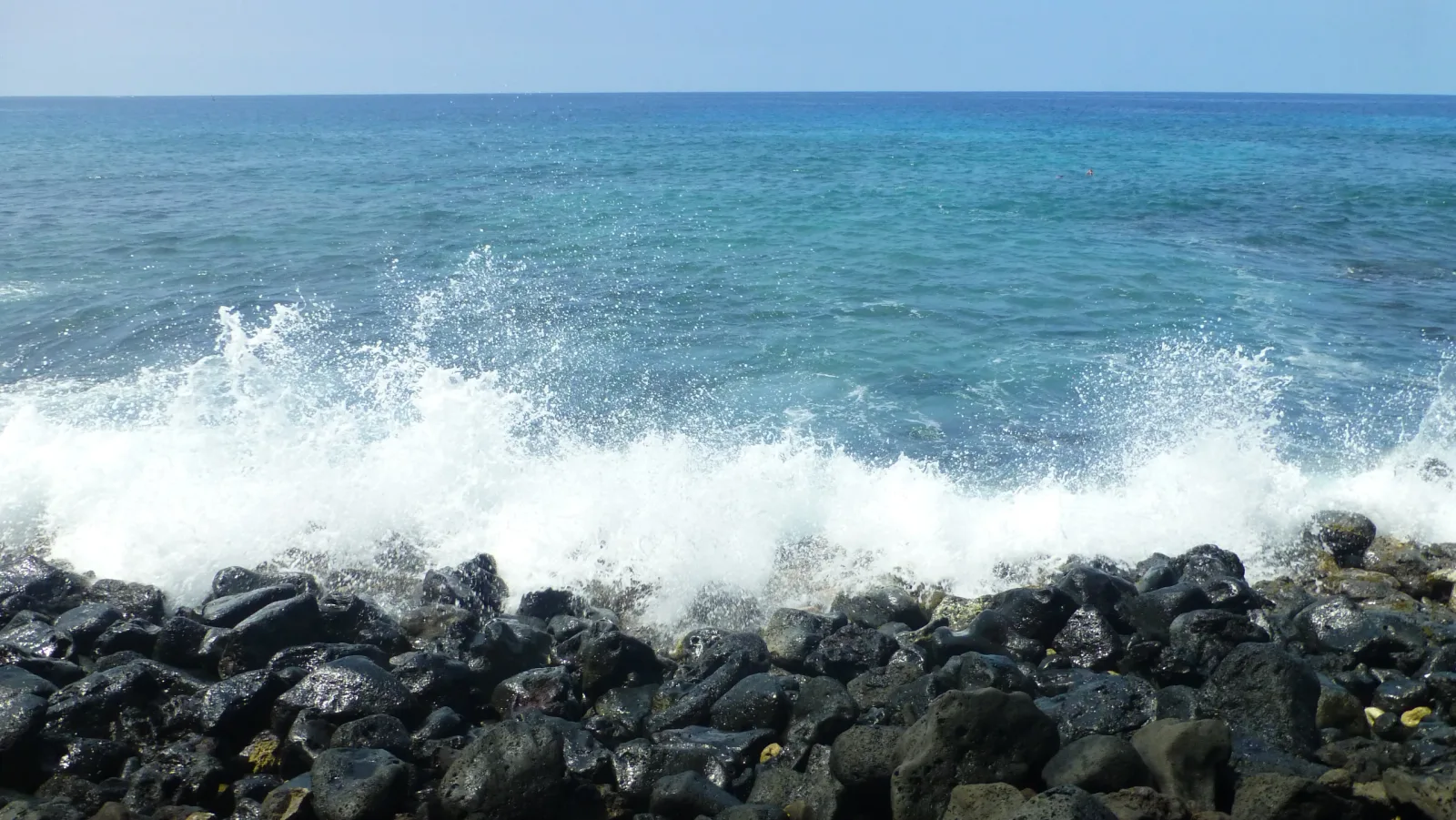 Küste mit schwarzen Lavafelsen und türkisem Meer